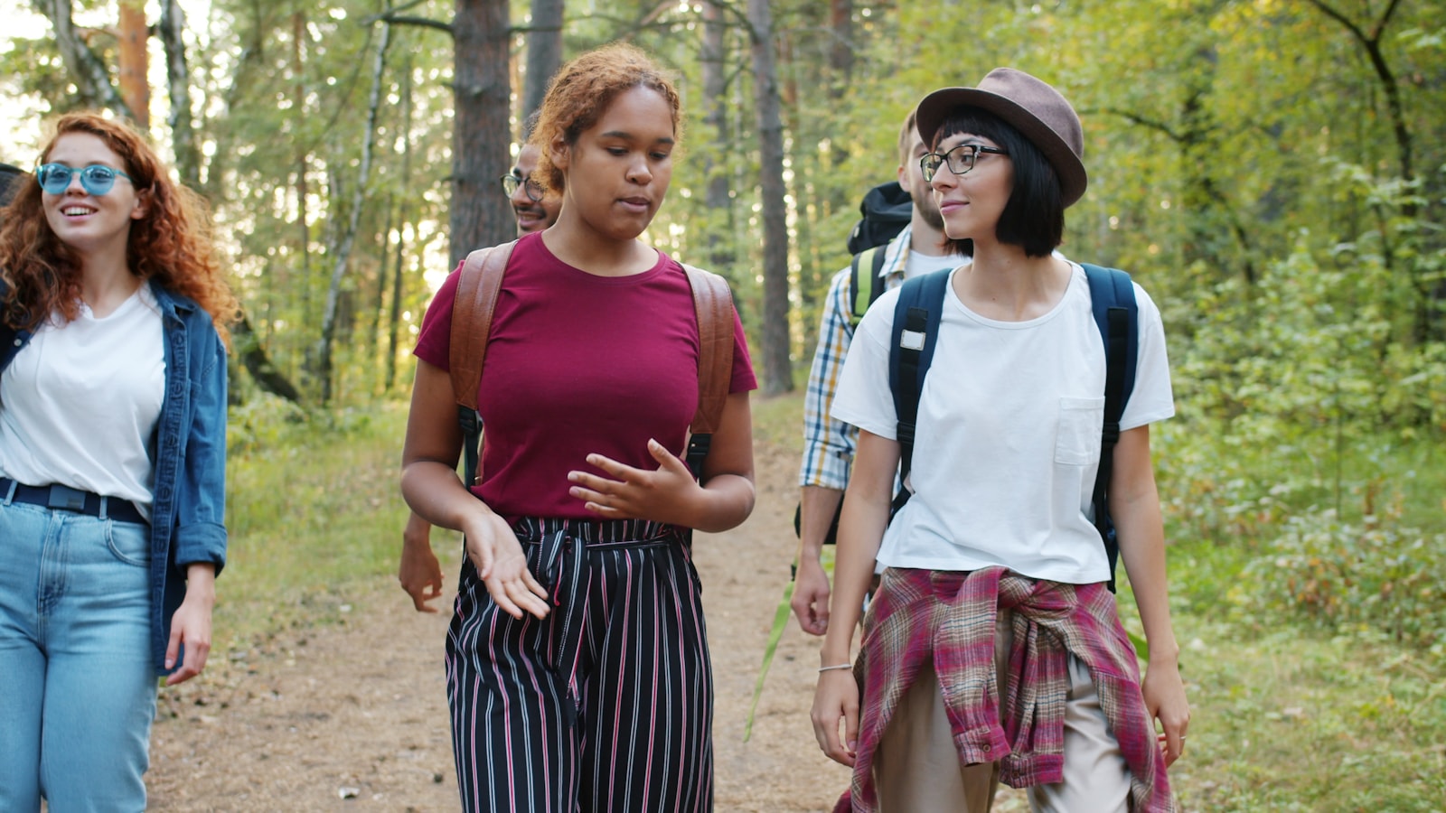 A small group of friends walking together through woodland