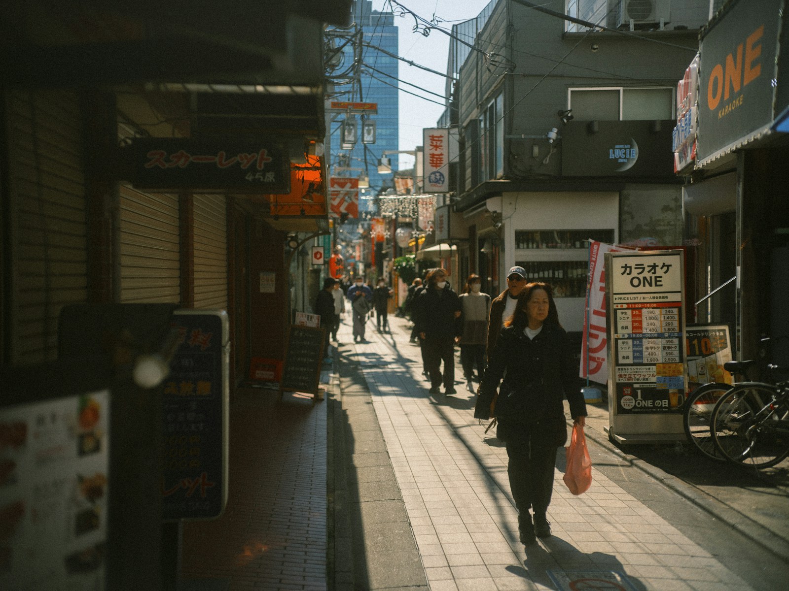 People walking through a sunlit street in Tokyo