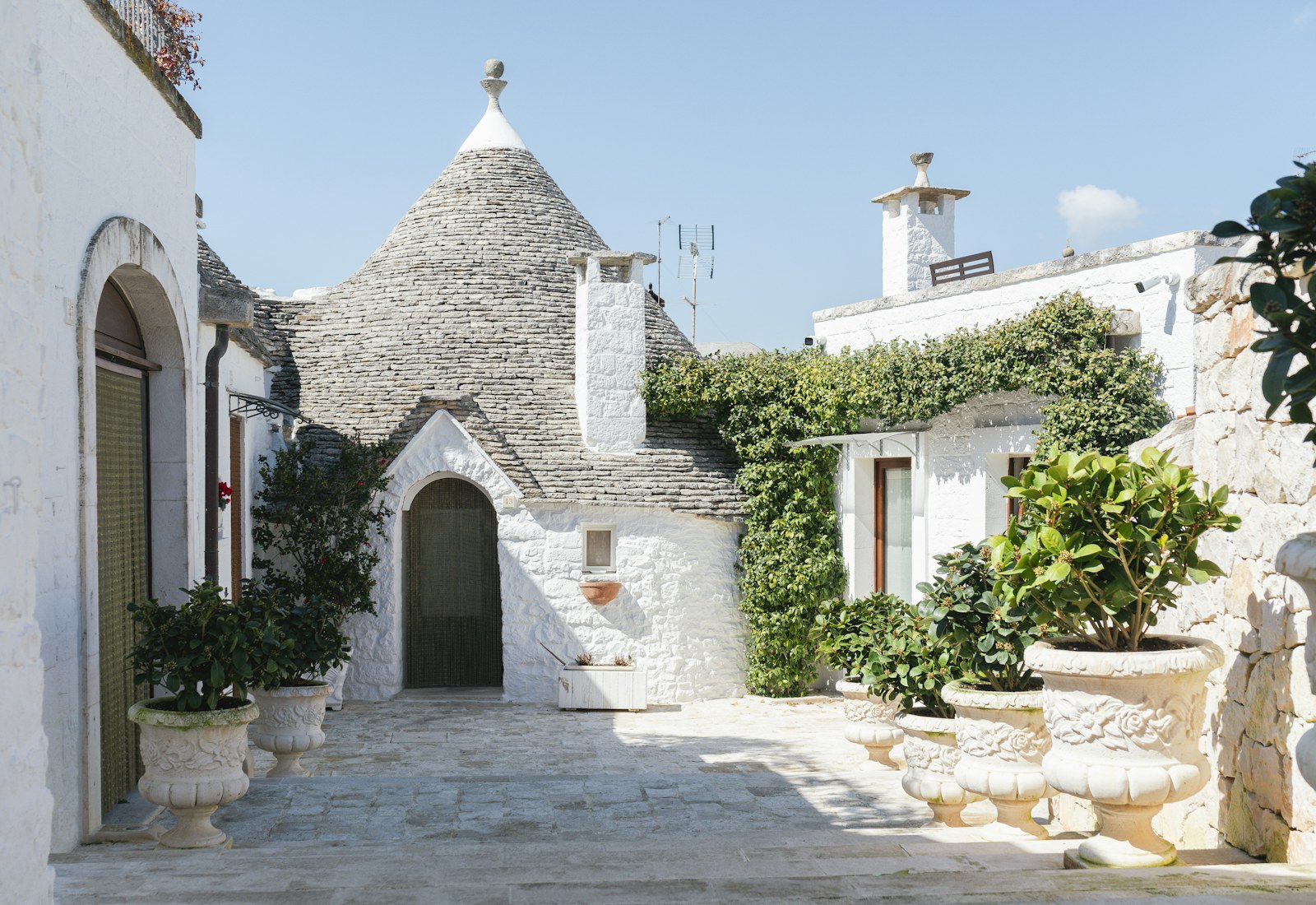 Whitewashed trulli houses in a sunny Puglian courtyard